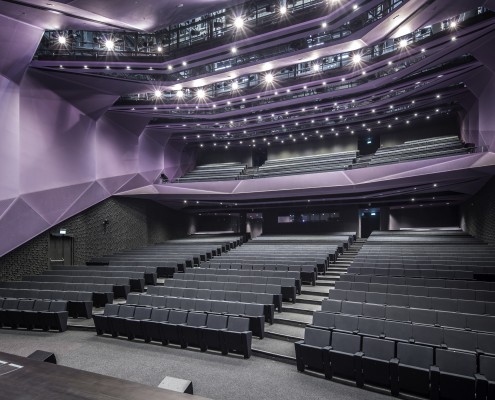 The use of gradation in colour, receding wall and ceiling modules in the Auditorium enhances its directional quality in an otherwise fairly static space
