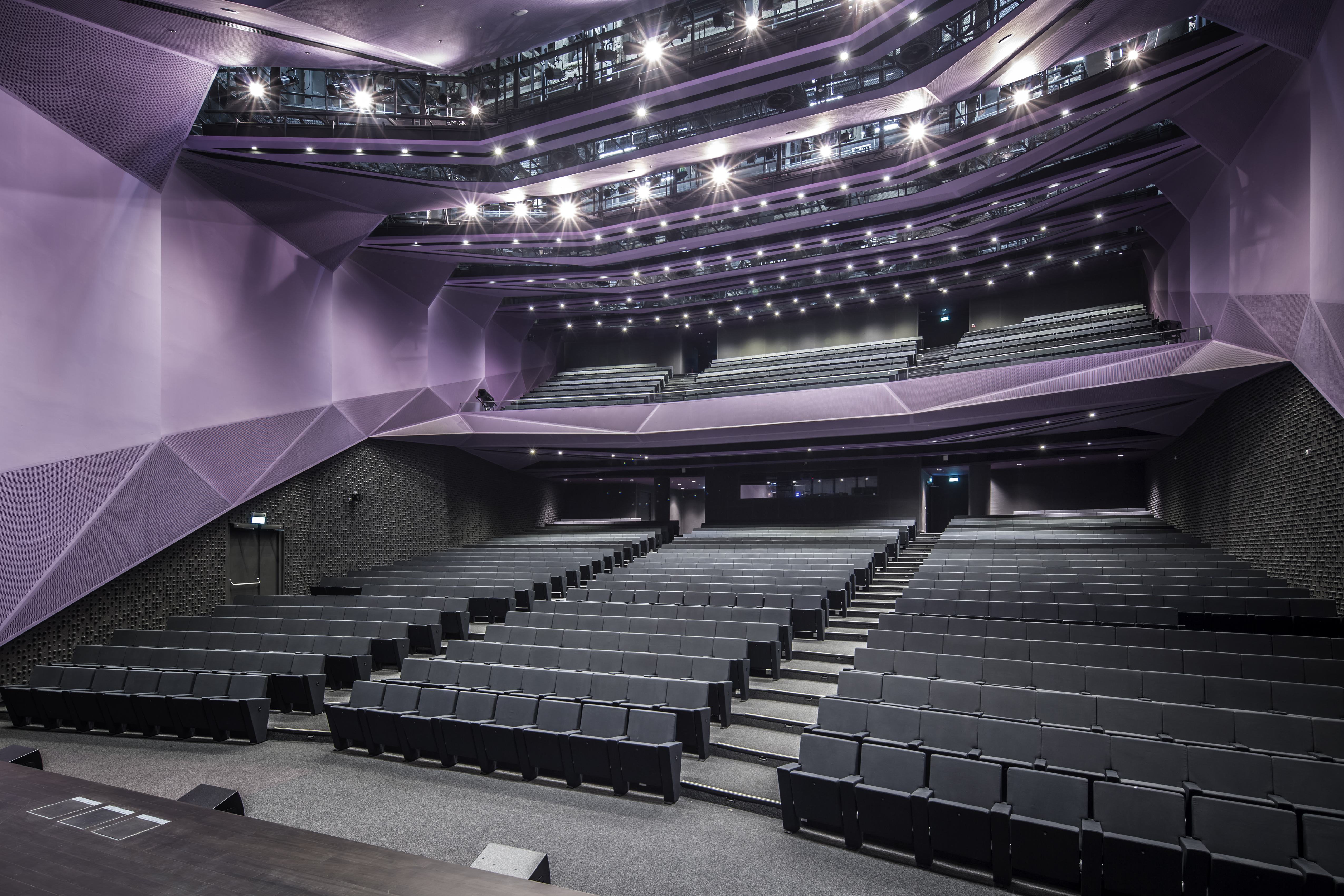 The use of gradation in colour, receding wall and ceiling modules in the Auditorium enhances its directional quality in an otherwise fairly static space
