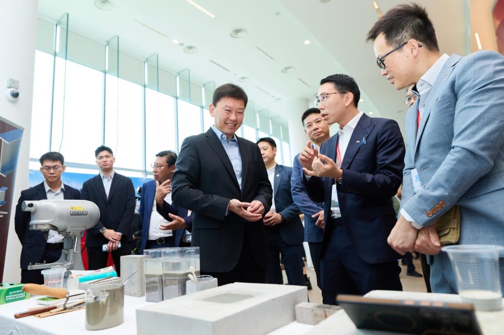 Minister for National Development Mr Chee Hong Tat viewing an ultra-low-carbon concrete demonstration developed through the Woh Hup–SIT collaboration
